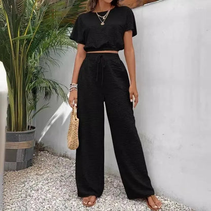 Tvådelat set för damer med kortärmad topp och raka byxor med vid be